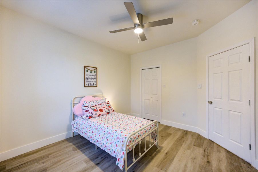 Inviting first-floor bedroom with generous closet space and a sleek ceiling fan.