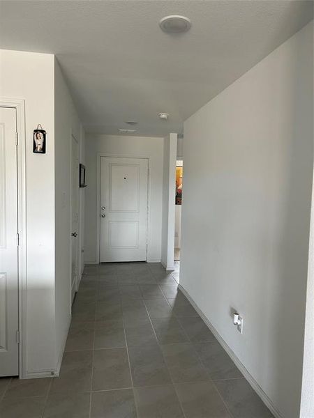 Corridor featuring tile patterned flooring Corridor featuring tile patterned flooring