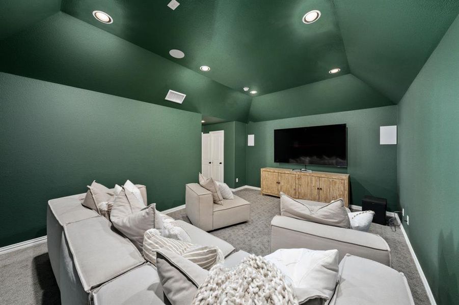 Media room featuring light carpet and vaulted ceiling