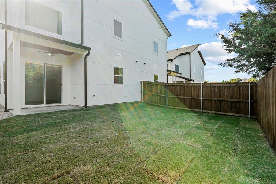 Fenced backyard with a patio and ceiling fan