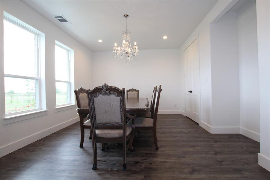 Dining room featuring dark wood-type flooring, a chandelier, and recessed lighting Dining room featuring dark wood-type flooring, a chandelier, and recessed lighting