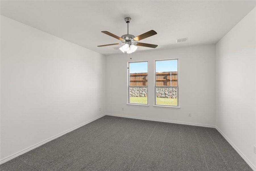 Carpeted spare room with ceiling fan