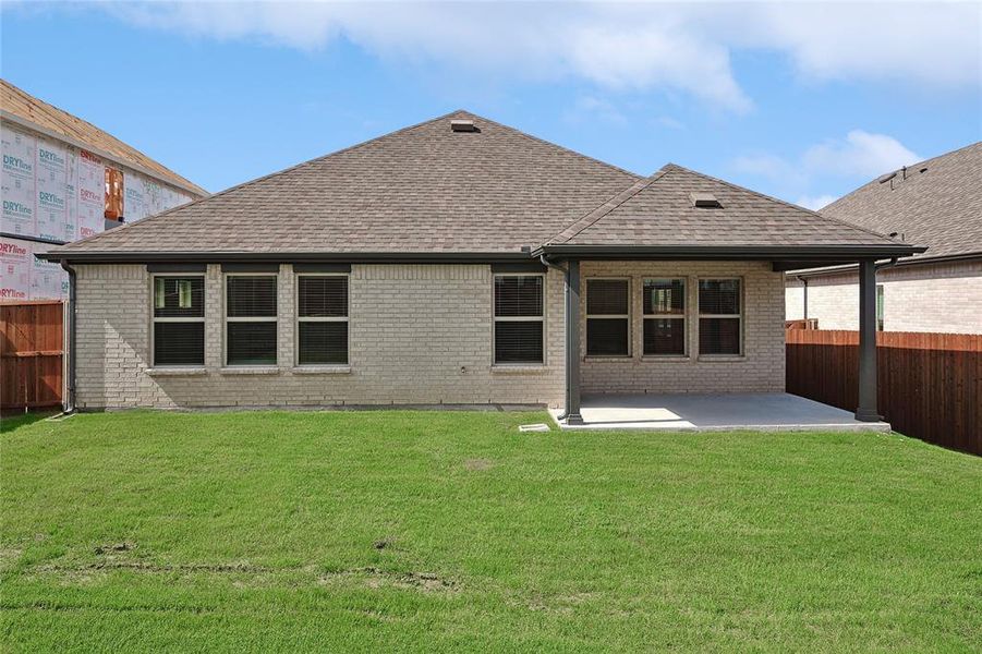 Back of property featuring a yard and a patio