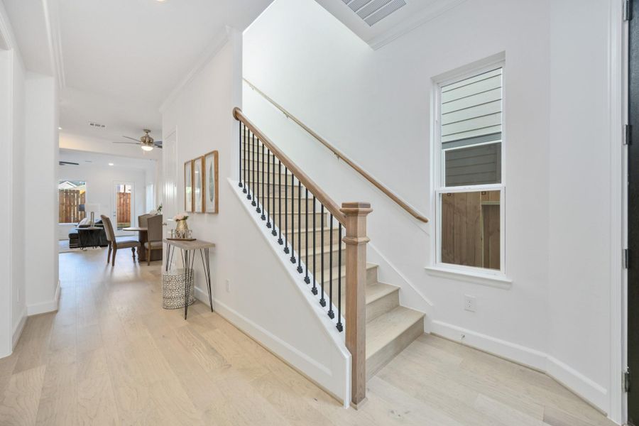 Hello, modern welcome moment! This entry sets the tone with warm wood tones, a statement staircase, and sunlight that practically greets you at the door.
