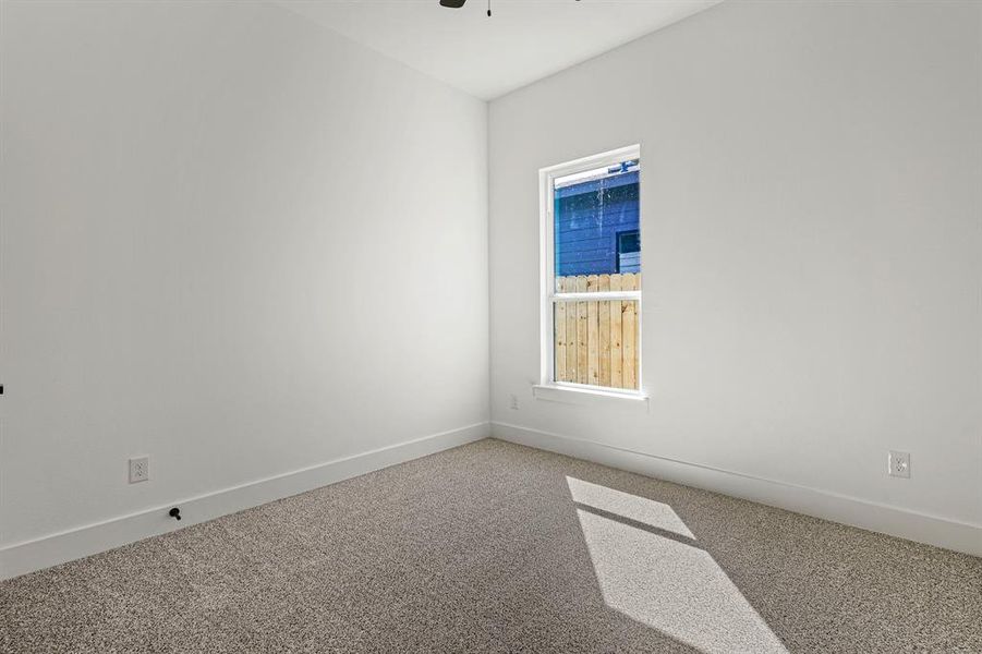 Unfurnished room with carpet, ceiling fan, and baseboards