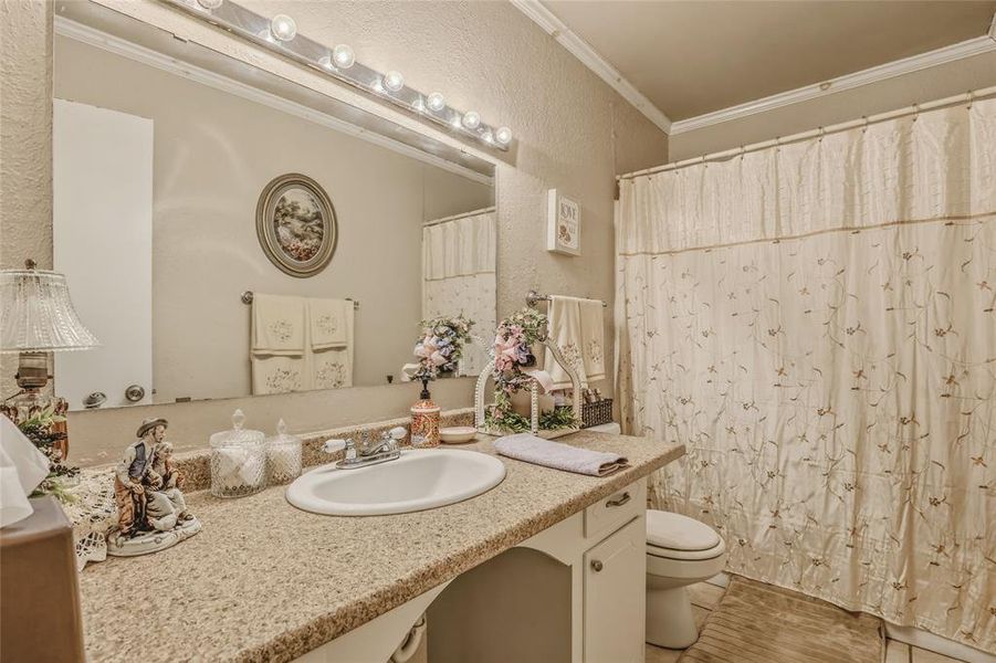 Bathroom vanity with a speckled countertop, integrated sink, and white cabinetry Bathroom vanity with a speckled countertop, integrated sink, and white cabinetry