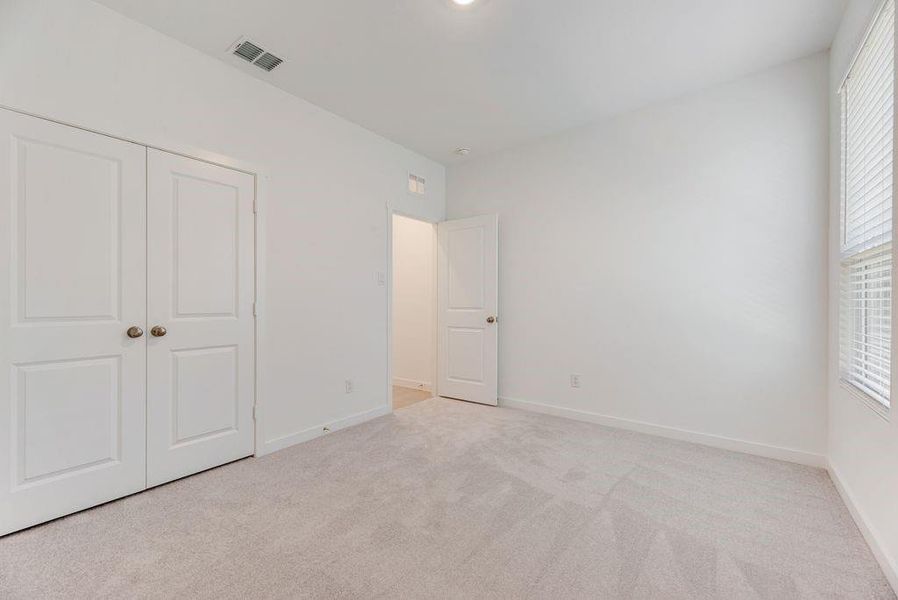 Unfurnished bedroom with carpet and a closet Unfurnished bedroom with carpet and a closet