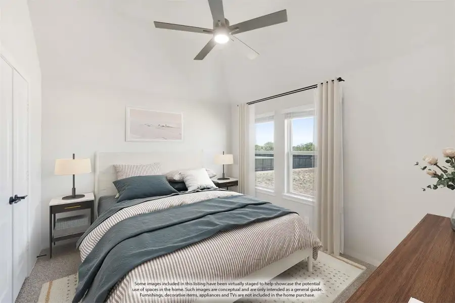 Bedroom with vaulted ceiling, ceiling fan, carpet flooring, and two windows with white curtains