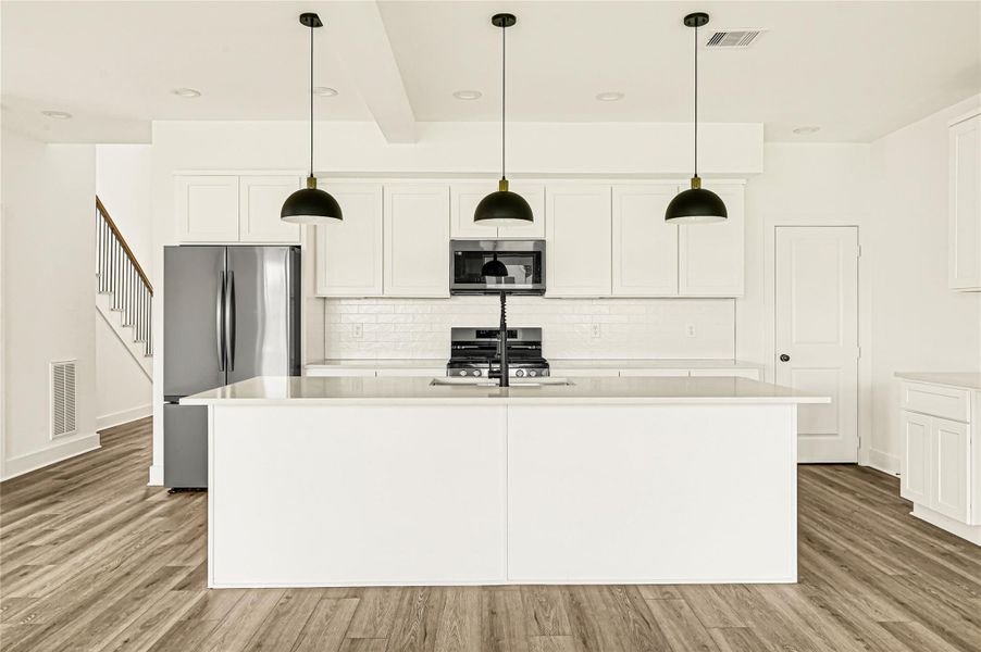 Oversized island with pendant lighting, perfect for meal preparation and entertaining. Oversized island with pendant lighting, perfect for meal preparation and entertaining.
