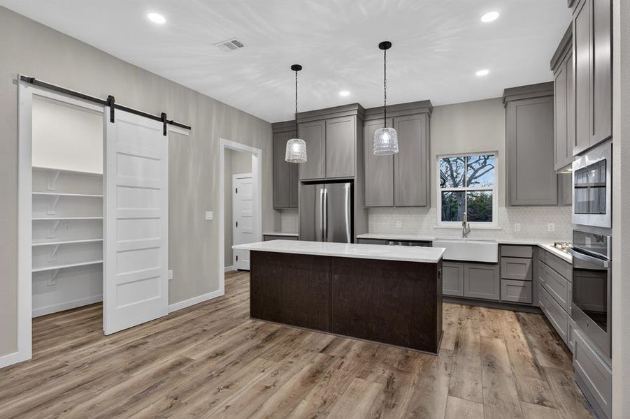 The kitchen includes a walk-in pantry with a sliding barn door.