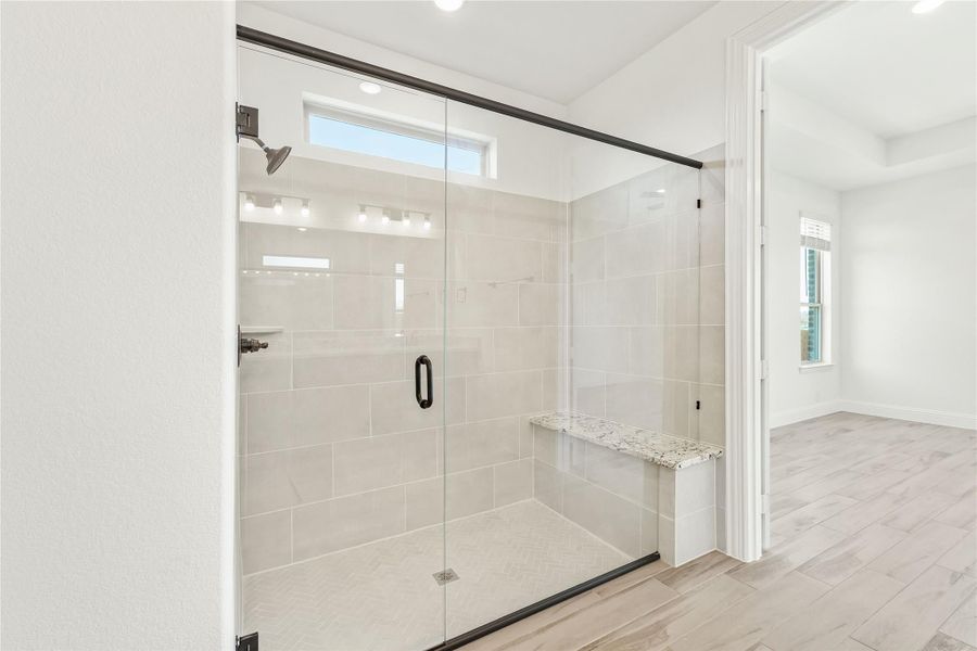 Walk-in shower with glass door, white tile walls, built-in bench, and small window above Walk-in shower with glass door, white tile walls, built-in bench, and small window above