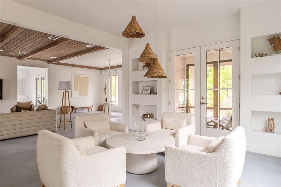 Living area featuring stairway, finished concrete floors, and built in shelves Living area featuring stairway, finished concrete floors, and built in shelves
