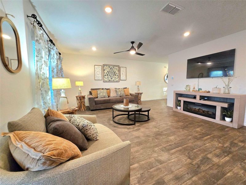 Open-concept living space featuring wood-finish flooring, recessed lighting, and a ceiling fan