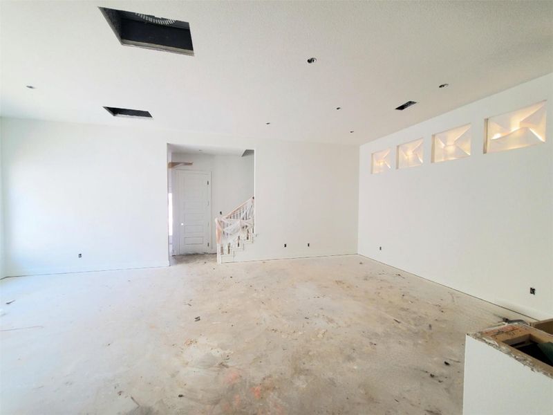 Unfurnished room featuring stairs and unfinished concrete floors