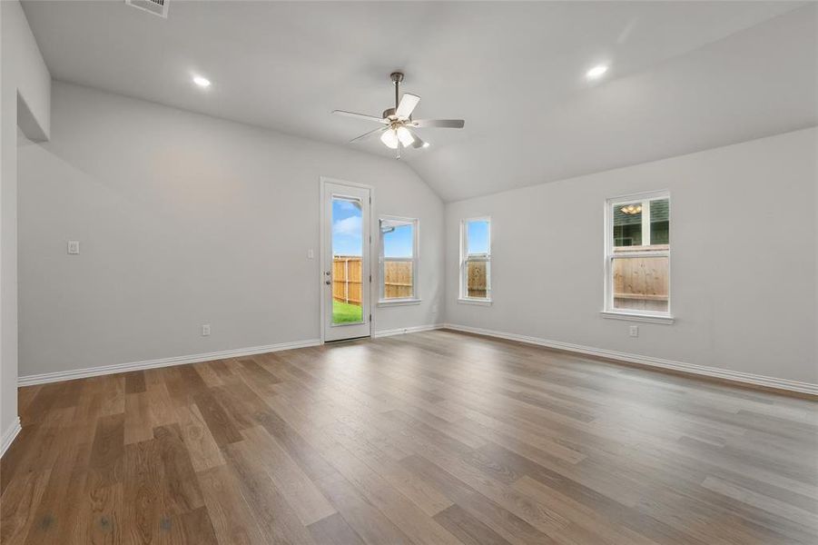 Spare room with a ceiling fan, vaulted ceiling, wood finished floors, baseboards, and recessed lighting Spare room with a ceiling fan, vaulted ceiling, wood finished floors, baseboards, and recessed lighting