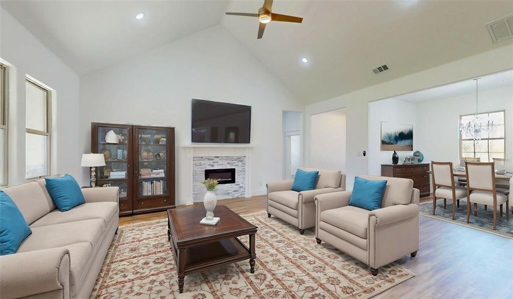 Living area featuring light wood-style floors, a fireplace, and visible vents