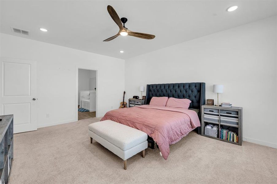 Carpeted bedroom with ceiling fan and ensuite bathroom