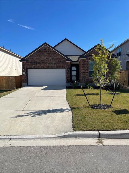 Single story home with brick siding, a garage, and driveway Single story home with brick siding, a garage, and driveway