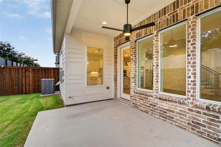Covered patio featuring a ceiling fan with integrated lighting, a concrete slab, and brick and siding exterior finishes Covered patio featuring a ceiling fan with integrated lighting, a concrete slab, and brick and siding exterior finishes