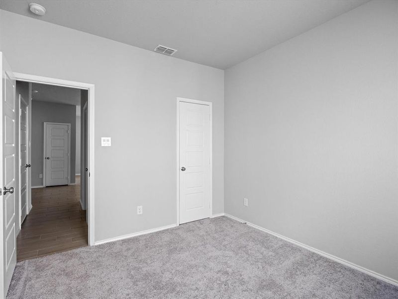 Unfurnished bedroom featuring baseboards and light carpet Unfurnished bedroom featuring baseboards and light carpet
