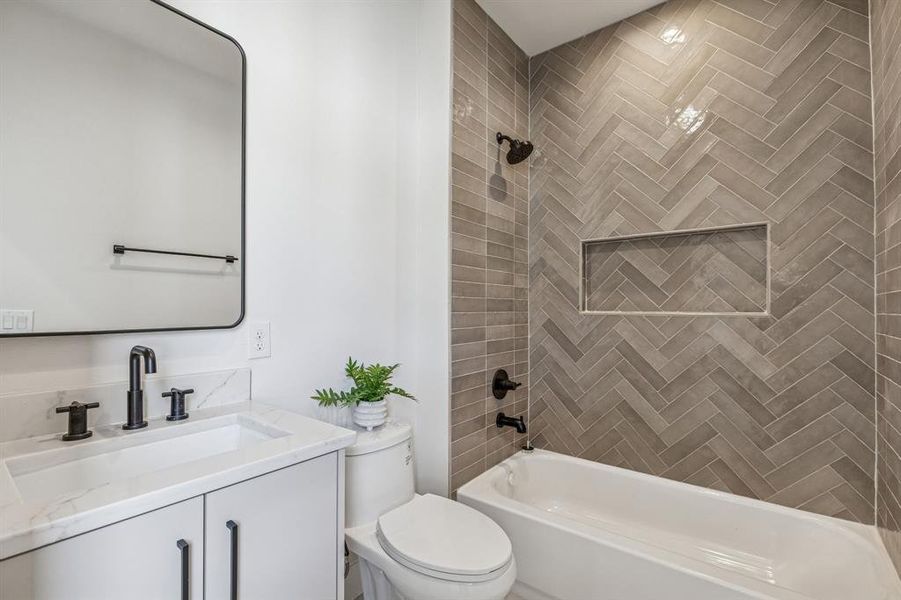 guest bathroom with vanity and shower/tub combination with decorative tile going to ceiling