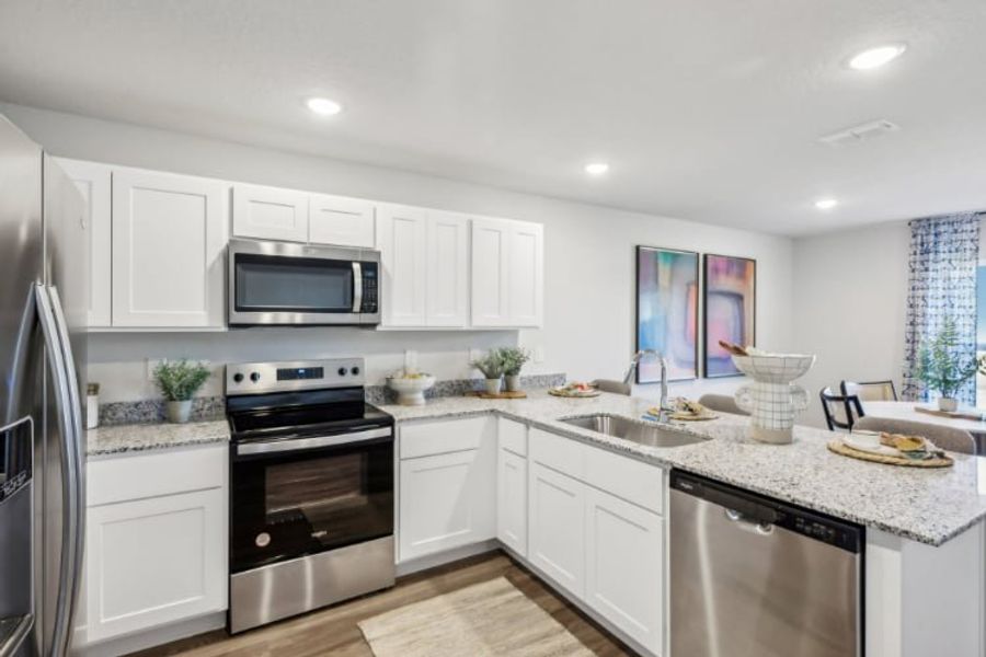 A kitchen with white cabinets.