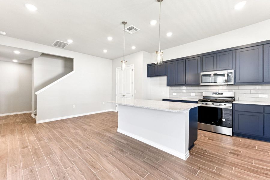 Kitchen featuring appliances with stainless steel finishes, tasteful backsplash, recessed lighting, light stone countertops, and a kitchen island Kitchen featuring appliances with stainless steel finishes, tasteful backsplash, recessed lighting, light stone countertops, and a kitchen island