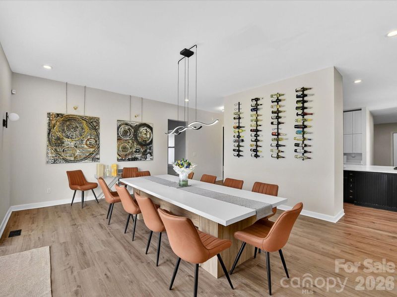 Stylish modern dining room featuring contemporary lighting, and a sleek wall-mounted wine display.