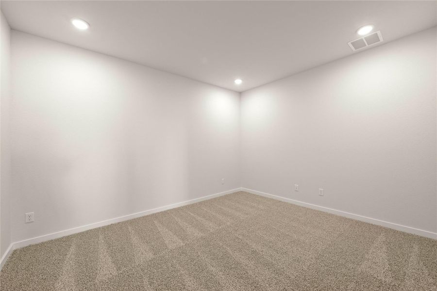 An empty room offers a blank canvas for personalization, illuminated by recessed lighting.