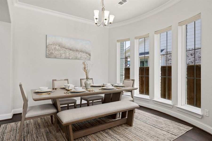 Dining room with ornamental molding, dark hardwood / wood-style flooring, and a chandelier