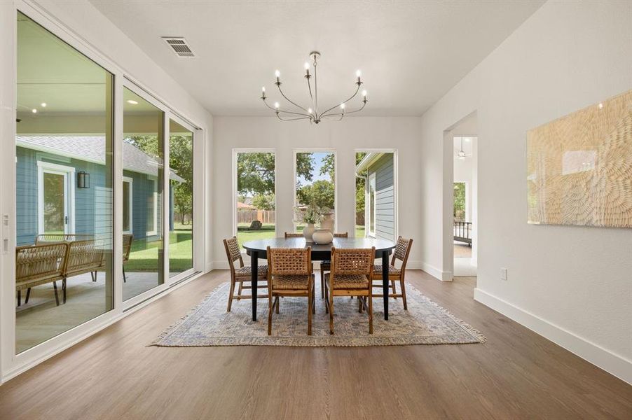 Dining space with a chandelier and wood finished floors Dining space with a chandelier and wood finished floors