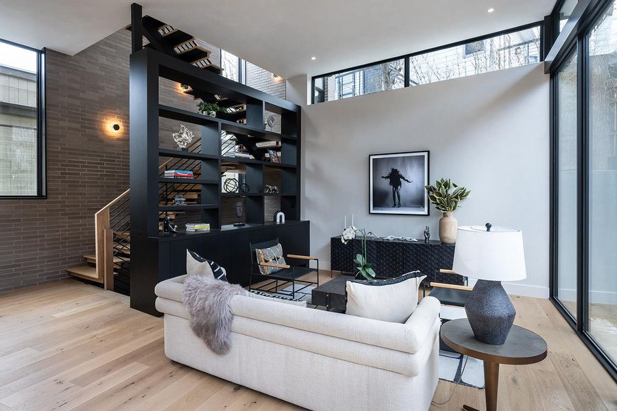 Blonde hardwood floors complement a modern living space featuring a floating staircase and floor-to-ceiling windows. Blonde hardwood floors complement a modern living space featuring a floating staircase and floor-to-ceiling windows.