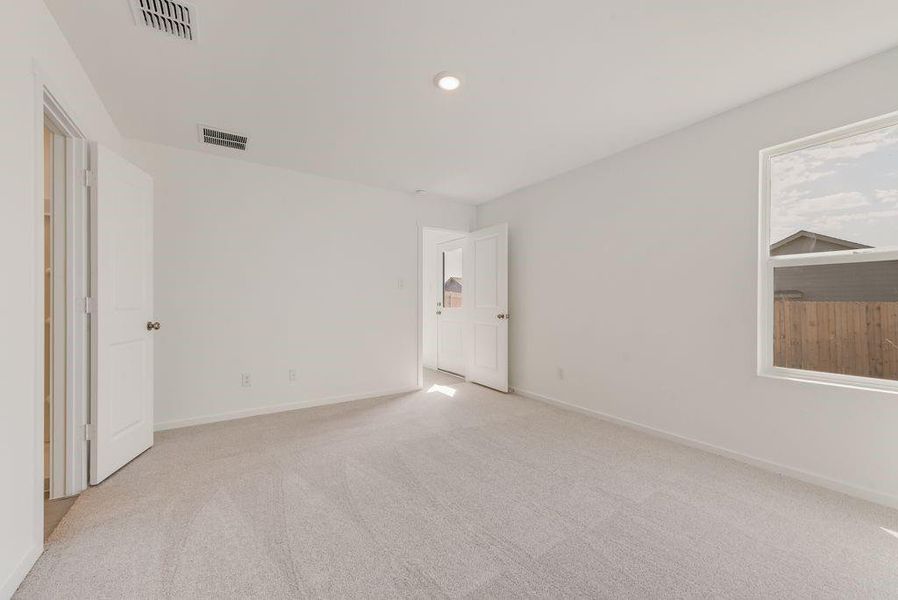 Spare room featuring light colored carpet and baseboards