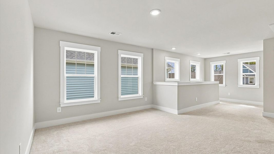 Vibrant carpeted loft offering flexibility as a study nook, game room, or second family space Vibrant carpeted loft offering flexibility as a study nook, game room, or second family space