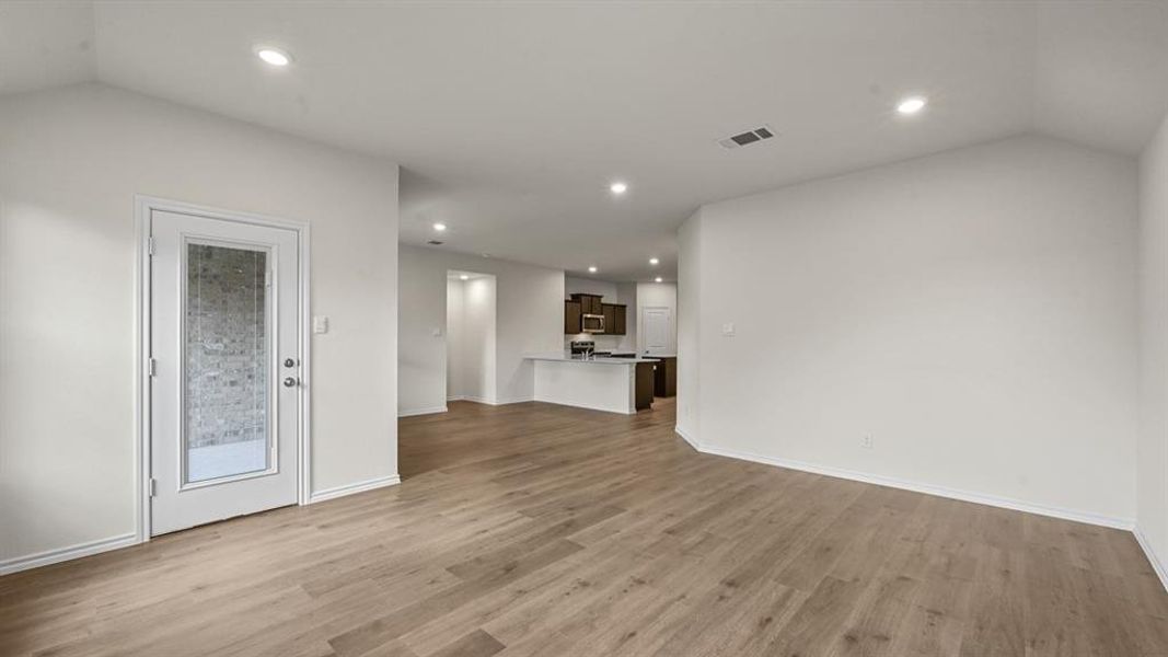 Unfurnished living room with light wood-style flooring, recessed lighting, and vaulted ceiling