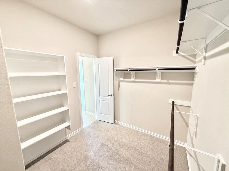 Walk in closet featuring light colored carpet Walk in closet featuring light colored carpet