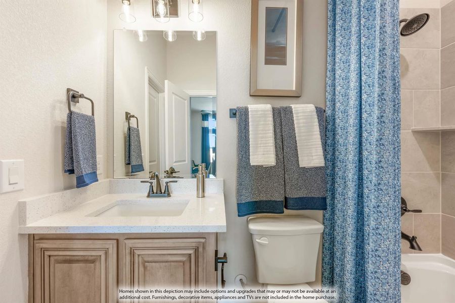 Bathroom with single vanity, white countertop, wood cabinets, and tiled shower-tub combo with blue curtain Bathroom with single vanity, white countertop, wood cabinets, and tiled shower-tub combo with blue curtain