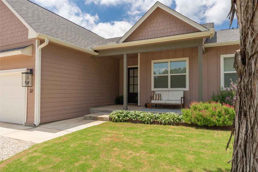 A welcoming facade with a covered porch offers delightful curb appeal, complemented by vibrant landscaping and a neatly kept lawn.