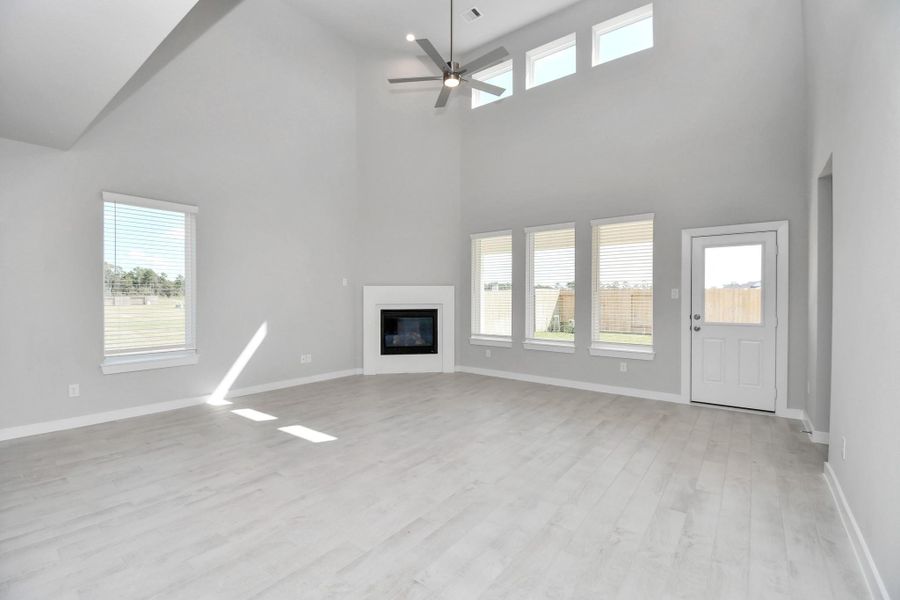 Gather the family and guests together in your lovely living room! Featuring soaring high ceilings, recessed lighting, ceiling fan, custom paint, gorgeous floors, and large windows that provide plenty of natural lighting throughout the day. Sample photo of completed home with similar floor plan. Actual colors and selections may vary. Gather the family and guests together in your lovely living room! Featuring soaring high ceilings, recessed lighting, ceiling fan, custom paint, gorgeous floors, and large windows that provide plenty of natural lighting throughout the day. Sample photo of completed home with similar floor plan. Actual colors and selections may vary.