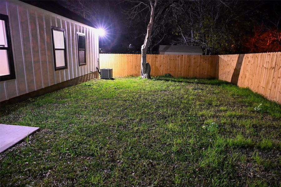 Yard at twilight featuring a fenced backyard