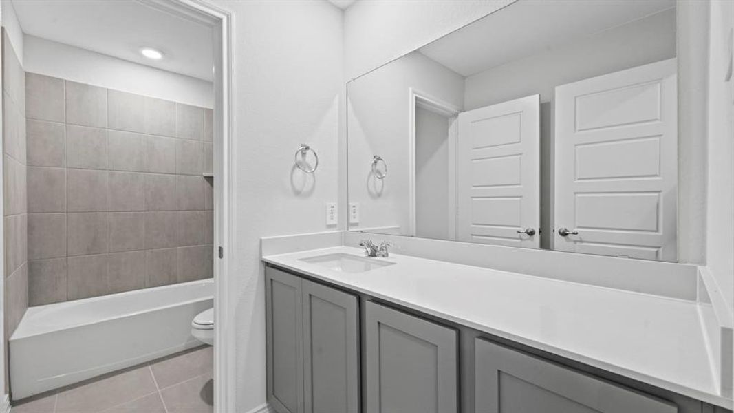 Full bathroom with light tile patterned flooring, vanity, and shower / tub combo with curtain Full bathroom with light tile patterned flooring, vanity, and shower / tub combo with curtain