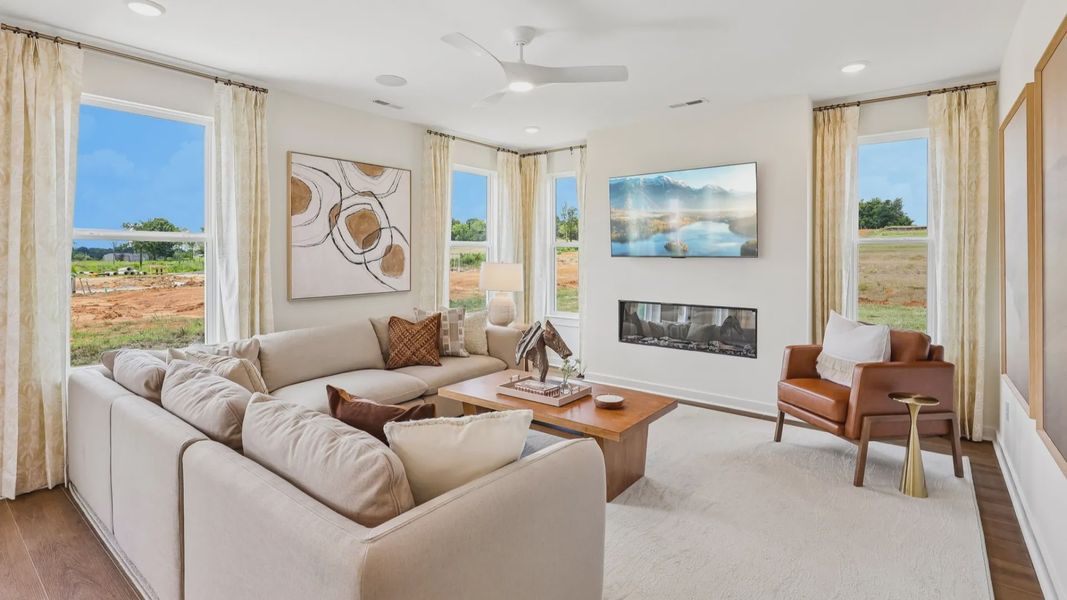 Gathering room with ceiling fan, windows, and fireplace