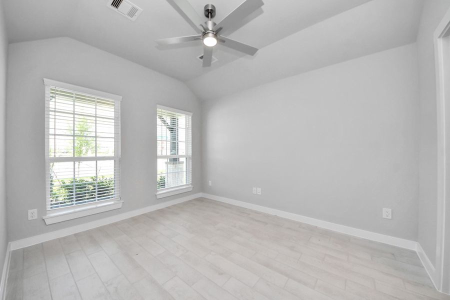 Secondary bedroom features plush carpeting, large windows that let in plenty of natural light, bright paint, and spacious closets. Sample photo of completed home with similar floor plan. Actual colors and selections may vary.