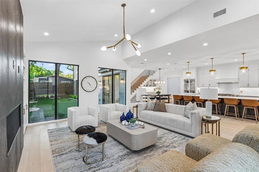 Open-concept living and kitchen space with soaring ceilings, designer lighting, and seamless flow, ideal for both everyday living and entertaining.