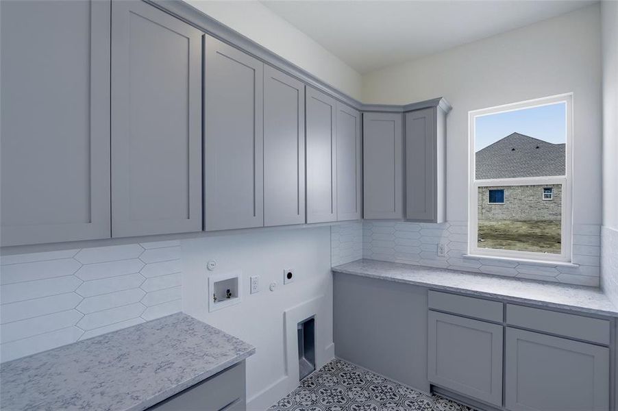 Laundry area with hookup for a washing machine, electric dryer hookup, hookup for a gas dryer, and cabinet space