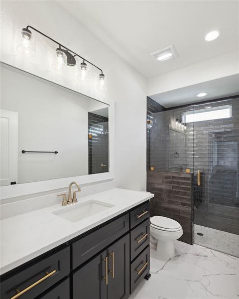 Bathroom with tile patterned flooring, walk in shower, toilet, and vanity