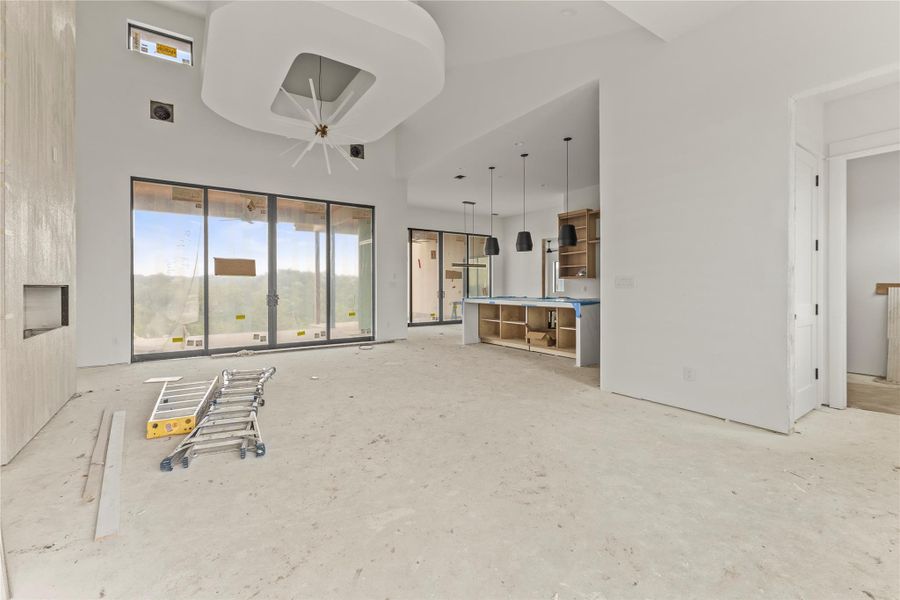 Spacious open-concept interior featuring high ceilings and extensive sliding glass doors Spacious open-concept interior featuring high ceilings and extensive sliding glass doors