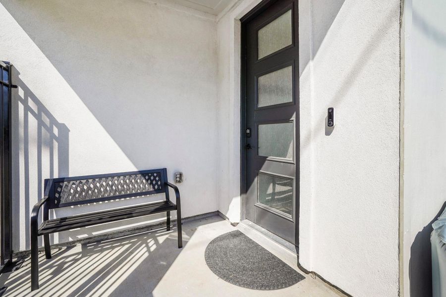 Sleek frosted glass door and inviting bench offers a nook to the entry of your new home.