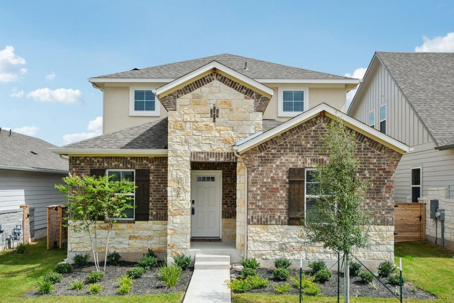 View of front of property with stone siding, brick siding, and roof with shingles View of front of property with stone siding, brick siding, and roof with shingles