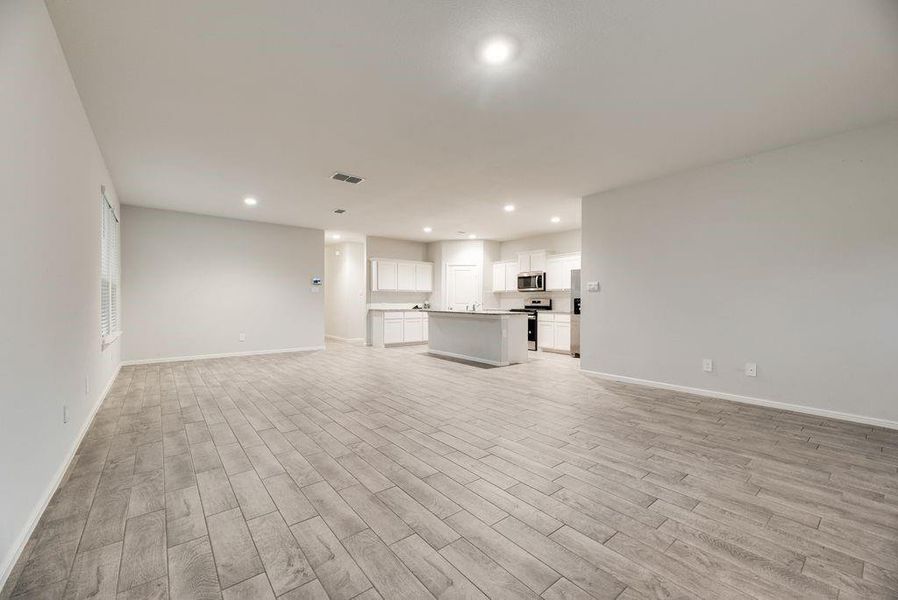 Expansive open-concept living area featuring wood-finish flooring and recessed lighting